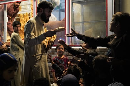 Un grupo de niños pide pan al cliente de una panadería, el 27 de septiembre. Los miles de establecimientos de este tipo en Kabul son un lugar habitual al que acuden mujeres y niños para pedir comida. Una pieza de pan cuesta unos 10 céntimos de euro y es la base de la alimentación de muchas personas.
