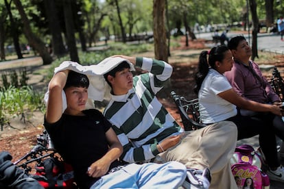 Jóvenes usan una prenda para hacerse sombra, el 16 de abril en la Alameda Central, en Ciudad de México.