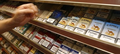 Un estanquero se dispone a coger un paquete de cigarrillos en un despacho de tabaco de París.