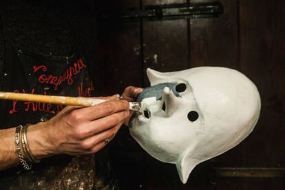 En la imagen, el artesano Massimo Boldrin pinta una máscara blanca con pintura gris, antes de añadir los detalles.