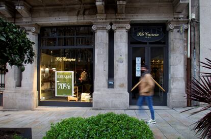 Una persona pasa frente a una tienda de moda infantil de Vigo, en enero