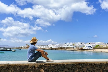 Un turista contempla las casas de Caleta del Sebo, en La Graciosa.