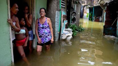 Una familia permanece junto a su casa inundada tras el paso del hurac&aacute;n Irma por Cuba el pasado 10 de septiembre.