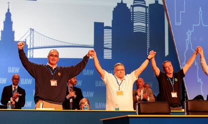 UAW President Shawn Fain raises arms with members of the International Executive Board during their 2023 Special Elections Collective Bargaining Convention in Detroit, Michigan, U.S., March 27, 2023.