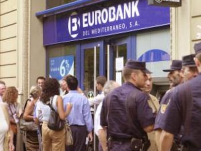 Clientes del Banco Eurobank del Mediterráneo hacen cola en una sucursal en Barcelona para intentar recuperar su dinero e informarse de la situacion de la entidad financiera intervenida por el Banco de España a petición propia por sus problemas patrimoniales. EFE/Archivo