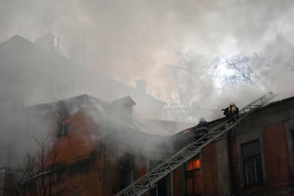 Los bomberos intentan apagar el fuego que envuelve uno de los edificios históricos ubicados en el patio del hotel Dnipro, en el centro de Kiev, (Ucrania).