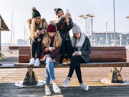 Unas jóvenes con sus teléfonos móviles.