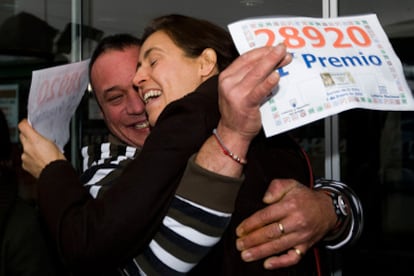Uno de los agraciados con el primer premio en la lotería de El Niño de 2009 se abraza a la lotera que lo repartió, en Terrasa ( Barcelona).