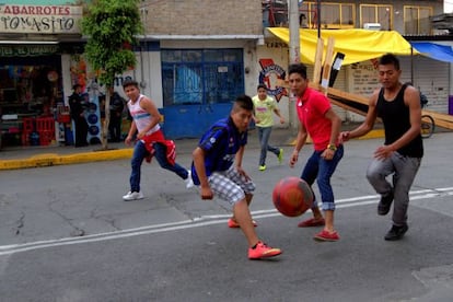 Jóvenes mexicanos juegan fútbol en el barrio de Iztapalapa.