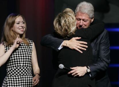 Bill Clinton abraza a su mujer, durante la celebración de su 60 cumpleaños, ante la mirada de su hija.