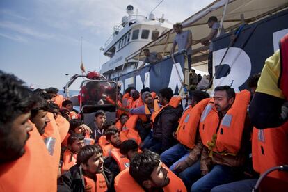 Migrantes rescatados por la ONG en alta mar son trasladados al buque 'Golfo Azurro'.