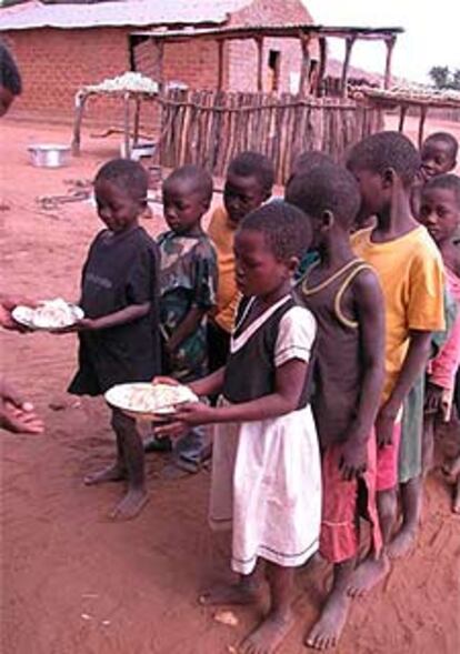 Varios niños de la provincia de Maniça reciben su almuerzo escolar.