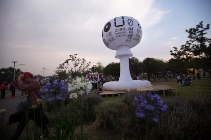 Visitantes caminan alrededor de un inflable con leyendas en contra el armamento nuclear.