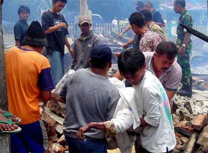 Un grupo de indonesios sacan un cadáver de los escombros de una casa destruida por el terremoto que ha tenido lugar en Solok, al oeste de Sumatra. Ahora queda el duro trabajo del desescombro y el rescate de los cadáveres y heridos.