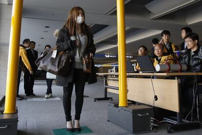 Una pasajera procedente de Japón pasa en el aeropuerto por escáner que mide sus niveles de radiactividad.