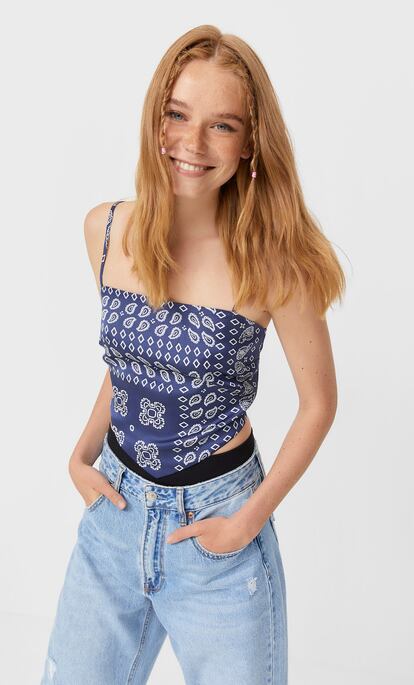 Con un diseño que imita a la forma de llevar un pañuelo atado a modo de top y con el estampado mítico de los 90, este cuerpo de Stradivarius tiene todo lo que una nostálgica busca. 12,99€.