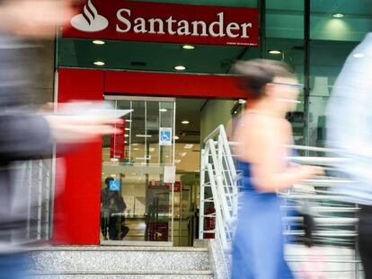 Personas pasan por delante de una sucursal del Banco Santander.