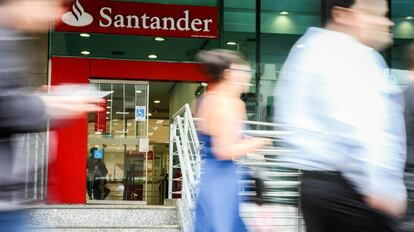 Personas pasan por delante de una sucursal del Banco Santander.