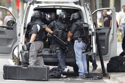 Tres agentes del Grupo Especial de Intervención de los Mossos se preparan para asaltar el piso vacío.