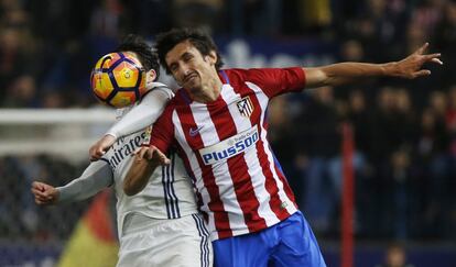 Stefan Savic (izquierda) del Atlético de Madrid e Isco del Real Madrid luchan por el balón.