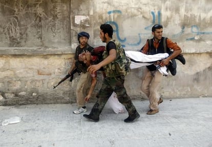 Milicianos del Ejército Libre de Siria trasladan ayer el cadáver de un compañero muerto en enfrentamientos con el régimen en Alepo.