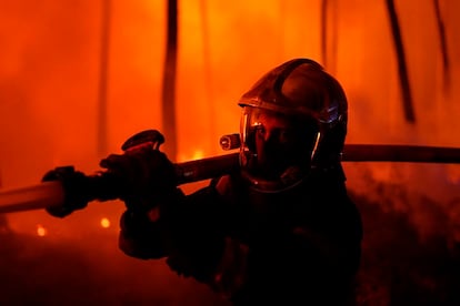 Un bombero sostenía una manguera el miércoles para luchar contra el fuego cerca de Hostens, al sur de Burdeos, en una foto proporcionada por el cuerpo de bomberos del departamento de Gironda.