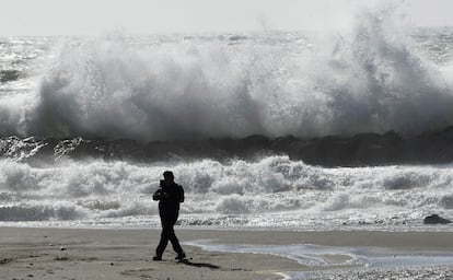 Una persona pasea por la playa de El Zapillo, en Almería, durante el temporal de viento que azota la provincia y por la que la AEMET ha declarado la alerta naranja por rachas de hasta 80 km/h, este martes.
