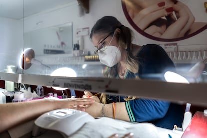 Una empleada haciendo la manicura en un salón en el centro de Madrid.