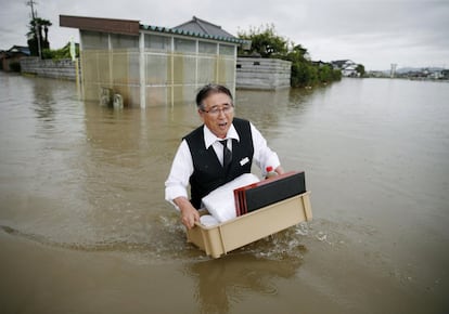 Um homem atravessa uma rua inundada em Oyama, prefeitura de Tochigi, ao nordeste de Tóquio (Japão).