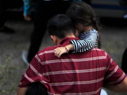Menina abraça seu pai após sua deportação do México a San Salvador.