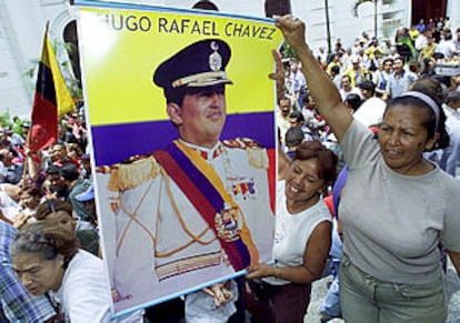 Simpatizantes de Hugo Chávez muestran un cartel con su fotografía en una calle de Caracas.