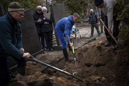 Oksana es abrazada por un familiar durante el funeral de su esposo, Volodymyr Nezhenets, en la ciudad de Kiev. Un pequeño grupo de reservistas están enterrando a su camarada, Volodymyr Nezhenets, de 54 años, fue uno de los tres asesinados el 26 de febrero en una emboscada que, según las autoridades ucranianas, fue provocada por "saboteadores" rusos.