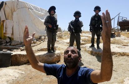 Un hombre clama al cielo rodeado por soldados israelíes durante la demolición de su casa en la localidad de Yatta, cerca de la ciudad cisjordana de Hebrón, Palestina.