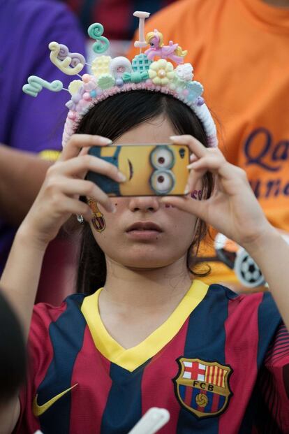 Enfundada en una camiseta del Barça, una espectadora del encuentro entre el conjunto dirigido por el Tata Martino y Tailandia toma una fotografía. 65.000 aficionados llenaron el estadio.