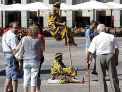 Unos hombres posan como estatuas vivientes para los turistas en la madrileña Plaza Mayor. EFE/Archivo