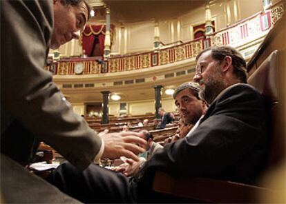 José María Michavila habla con Mariano Rajoy y Ángel Acebes durante el debate en el Congreso.