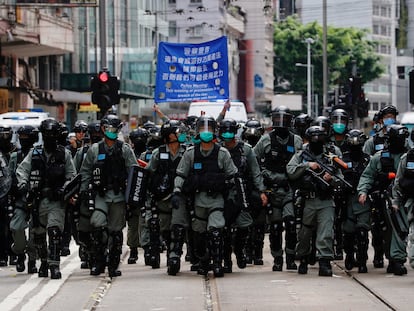 Un grupo de policías antidisturbios en Hong Kong camina durante una marcha de protesta contra la nueva ley de Seguridad Nacional