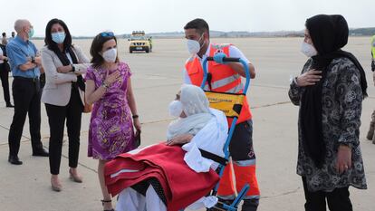 La ministra de Defensa, Margarita Robles, saluda a una mujer afgana evacuada a su llegada a la base de Torrejón de Ardoz, este miércoles.