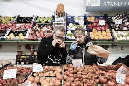 Bottura huele el aroma de un tomate en una frutería del mercado tradicional Albinelli.