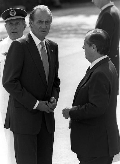 El rey Juan Carlos ( i) conversa con Sabino Fernández Campo ( d) , jefe de la Casa Real, mientras esperan la llegada de Rodrigo Borja, presidente de Ecuador, de visita oficial en Madrid en 1989