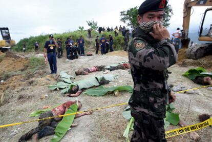 Varios policías examinan el lugar de una matanza causada por disputas entre clanes en la provincia de Maguindanao, en 2009.