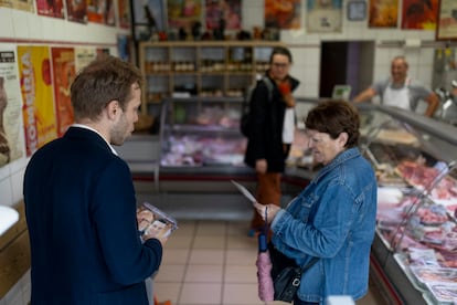 Charles Alloncle reparte propaganda electoral en una carnicería de Maugio. 