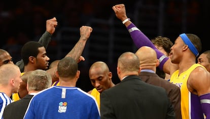 Los jugadores de los Lakers escuchan las instrucciones de los técnicos durante un descanso.