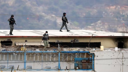 O corpo de um preso aparece rodeado de policiais no teto do Presídio do Litoral em Guayaquil (Equador), na manhã seguinte ao início dos distúrbios, em 13 de novembro de 2021.