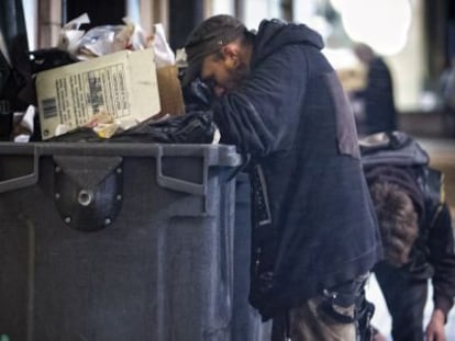 Una persona regira les escombraries a Barcelona.