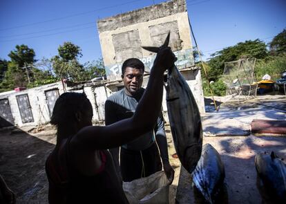 El pescador submarino Rick Walker, de 35 años, vende su captura a un comprador en un mercado de pescado en White River (Jamaica). Walker recuerda la temprana oposición al santuario de peces.