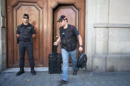 Civil Guard officers walk out of Catdem and Fòrum Barcelona after searching the premises in August.