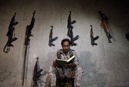 Un combatiente rebelde sirio lee el Corán en el suburbio de Al-Zahraa, en las afueras del oeste de la ciudad norteña de Alepo. 