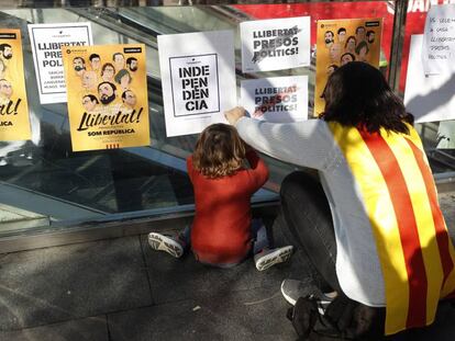 Una mujer y un ni&ntilde;o pegan carteles por la independencia catalana el 5 de noviembre. 