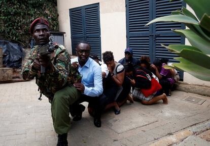 Varias personas son evacuadas de la zona atacada con la ayuda de un soldado keniano.